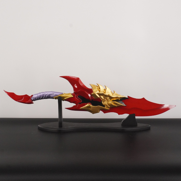 Red and gold weapon model on a stand against a gray background