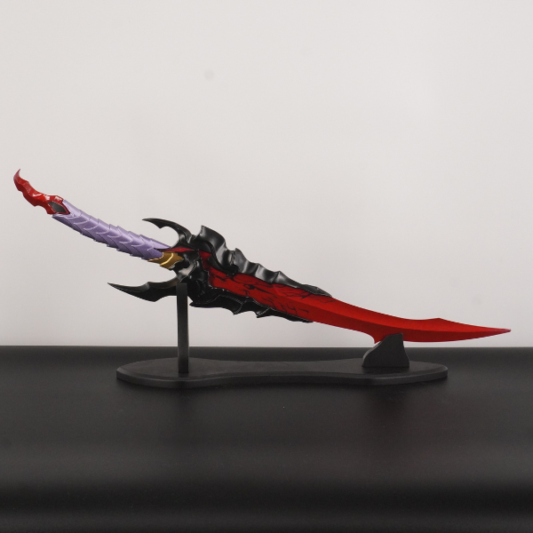 Decorative sword model on a stand against a plain background