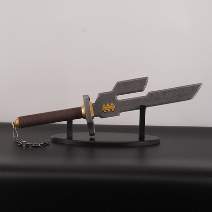 Decorative sword with a brown handle and gold accents on a black stand against a gray background