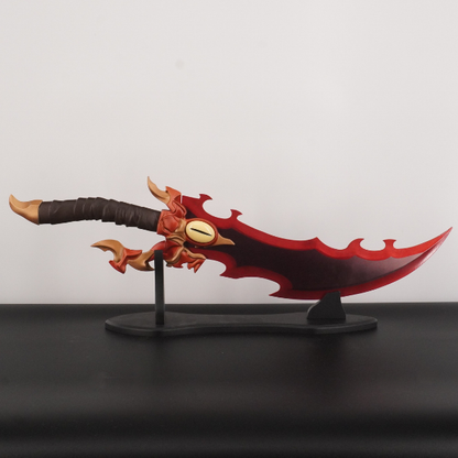 Decorative sword with red blade and brown handle on a stand against a plain background